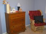 Jacob's room, slightly blurry, showing his dresser and the rocking chair cover and pillow that Kathy made for him