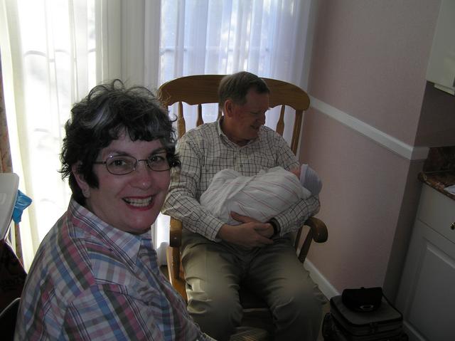 Grandma Hanson beams with joy while Grandpa rocks Lacy